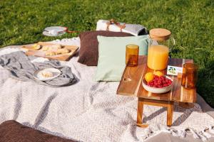 una mesa de picnic con una bandeja de fruta y una botella de zumo de naranja. en Casa cu Salcâmi, en Moieciu de Jos