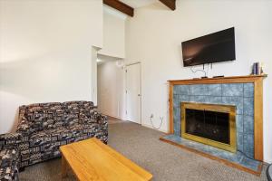 a living room with a couch and a fireplace at Cedarbrook Queen Suite 106 in Killington