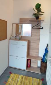 a room with a white refrigerator and a shelf at Be Home! Apartment Gratkorn in Gratkorn