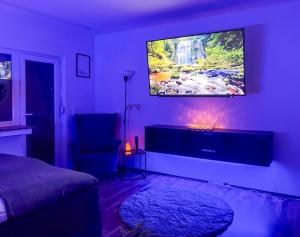 un soggiorno con TV a parete di Relax Oasis with 65 SmartTV, Kitchen and Balcony a Duisburg