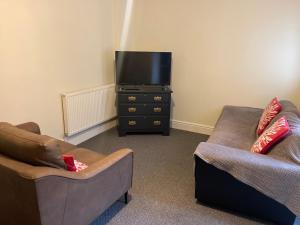 a living room with two couches and a flat screen tv at Marks Place in Liverpool