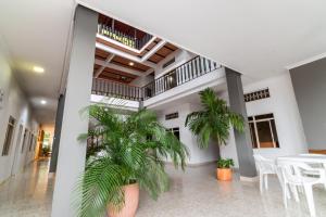 - un hall avec deux palmiers, une table et des chaises dans l'établissement HOTEL MONTANAR HOME, à La Dorada