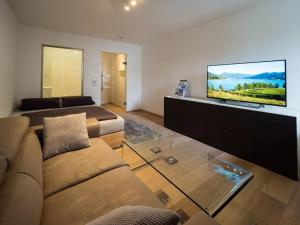 een woonkamer met een bank en een flatscreen-tv bij Tegernsee - Tolles, zentrales Appartement in Tegernsee