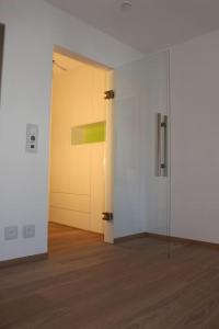 an empty room with a glass door and a hallway at Tegernsee - Tolles, zentrales Appartement in Tegernsee
