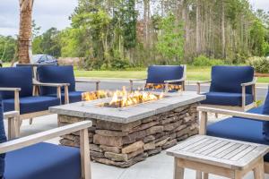 eine Terrasse mit einer Feuerstelle mit Stühlen und einem Tisch in der Unterkunft La Quinta Inn & Suites by Wyndham Valdosta in Valdosta