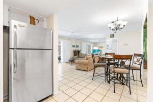 a kitchen and living room with a refrigerator and a table at Crescent Arms By Beachside Management in Sarasota