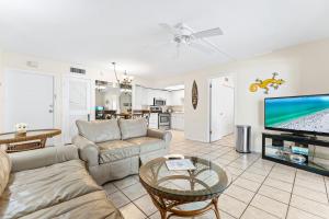 a living room with a couch and a tv at Crescent Arms By Beachside Management in Sarasota