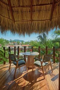 un patio con mesa y sillas en una terraza en La Villa Luz (sólo adultos), en Zihuatanejo