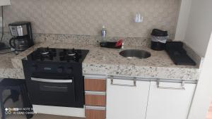 a kitchen counter with a stove and a sink at Estilo Bela Vista 308 in Cabedelo