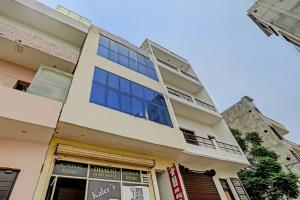 a building with blue windows on the side of it at OYO Dhalio Guest House in Patiāla