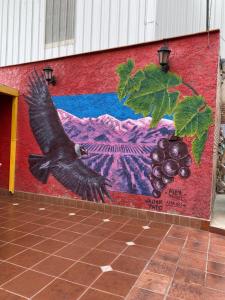 a painting of a bird flying in front of a wall at Hostel Ruca Potu in Mendoza