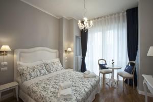 um quarto com uma cama branca, uma mesa e cadeiras em B&B La Nannina em Florença
