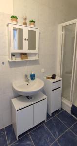 a white bathroom with a sink and a mirror at Be Home! Apartment Gratkorn in Gratkorn