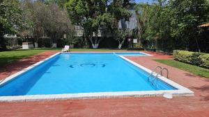 una gran piscina azul en un patio en Hotel O Puente, en San Juan del Río