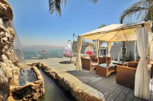 a house with a wooden deck with a water fountain at Ahuzat Kinorot in Tiberias