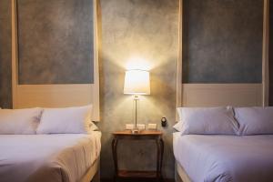 um quarto com duas camas e um candeeiro sobre uma mesa em Casa Montespejo B&B em Querétaro