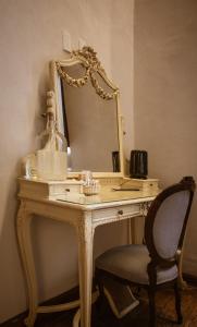um toucador com um espelho e uma cadeira em Casa Montespejo B&B em Querétaro