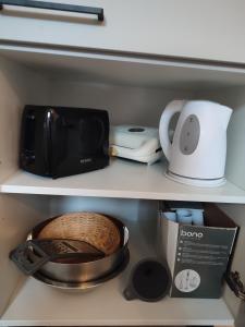 a kitchen shelf with a microwave and a toaster at Be Home! Apartment Gratkorn in Gratkorn +6 photos
