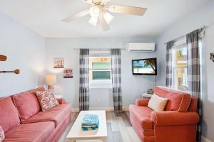 a living room with two red couches and a ceiling fan at Upham Beach Inn - #8 1BR Suite in St. Pete Beach