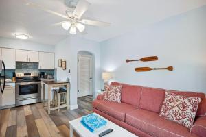 a living room with a red couch and a kitchen at Upham Beach Inn - #8 1BR Suite in St. Pete Beach