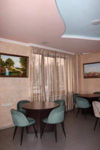 a dining room with two tables and chairs and a window at RL Hotel in Stepʼanavan