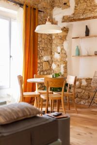 una mesa y sillas en una habitación con una pared de piedra en La Maison des Lamanon en Salon-de-Provence