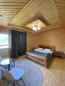 a bedroom with a bed in a wooden room at Villa Filiak in Yablunytsya