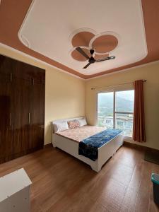 1 dormitorio con 1 cama y ventilador de techo en Host Labs Homestay - Premium View - Close to Kaichi Dham, Bhimtal, Sattal, and more, en Bhimtal