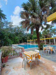 una mesa y sillas junto a una piscina en Centro Social Ecoturistico La Alberca, en José María Morelos