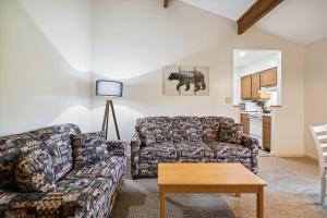 a living room with a couch and a table at Cedarbrook Deluxe Two Bedroom Suite with outdoor heated pool 21202 in Killington