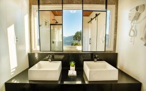 two sinks in a bathroom with a window at Pousada Fogo Eterno in Urubici