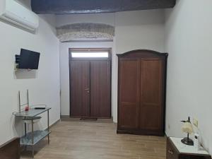 a room with a door and a table and a tv at B&B Vatra in Civita