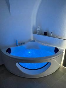 a blue bath tub in a white room with at Greta’s suite & private spa in Perinaldo