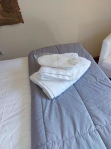 dwa białe ręczniki siedzące na łóżku w obiekcie Suite Korfes-Κορφές-Σ Αυτόνομη Σουίτα με Τζάκι στην Βίλα Κορφές w mieście Karpenision