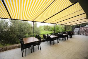 un restaurante con mesas y sillas y un dosel amarillo en Assos No9 Hotel, en Canakkale