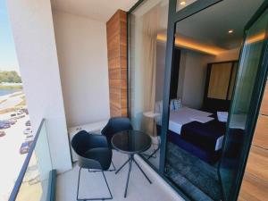 Cette petite chambre comprend un lit, une table et des chaises. dans l'établissement Hotel Nava, à Eforie Nord
