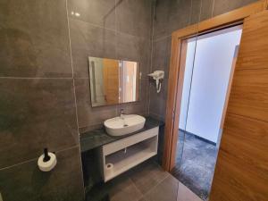 La salle de bains est pourvue d'un lavabo et d'un miroir. dans l'établissement Hotel Nava, à Eforie Nord