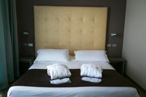 a bed with two white towels on it at Yes Hotel Touring & SPA in Rimini