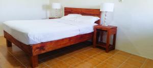 a bedroom with a bed and a night stand with a lamp at Toafa Lodge in ‘Ohonua