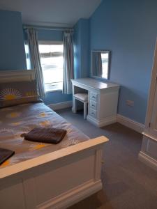 a bedroom with a bed and a desk and a mirror at Seashells, Newry, Anglesey - Ideal for the ferry crossing to Ireland in Holyhead