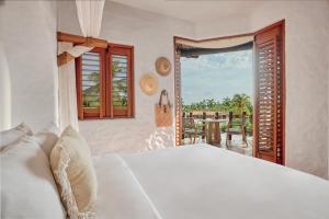 a bedroom with a bed and a view of a patio at La Villa Luz (sólo adultos) in Zihuatanejo