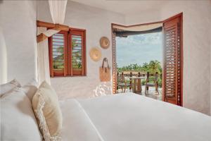 a bedroom with a bed and a view of a patio at La Villa Luz (sólo adultos) in Zihuatanejo