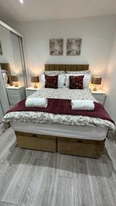 sypialnia z dużym łóżkiem z czerwonymi poduszkami w obiekcie 179 church Road w Londynie
