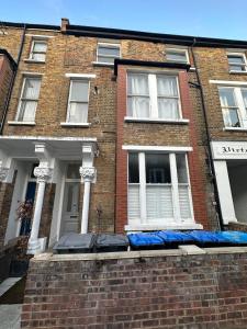 a brick building with blue mattresses in front of a window at Delightful new ensuite bedroom with stunning shared kitchen & living room -1C The Charteris in London