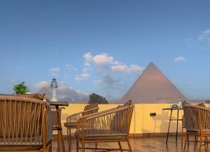 un patio con sillas y vistas a las pirámides. en Pyramids Glory INN, en El Cairo