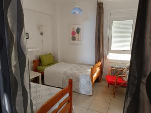 1 dormitorio pequeño con 1 cama y 1 silla en Mare e Monti2, en Agios Konstantinos