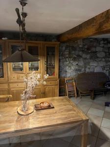 cocina con mesa de madera y pared de piedra en Maison en vallée d’Ossau, en Sainte-Colome