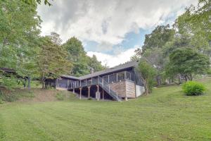 a house with a black roof and a grass field at Brevard Retreat Fireplace, Deck and Screened Porch! in Brevard