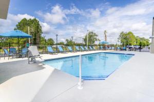 a large swimming pool with chairs and umbrellas at La Quinta Inn & Suites by Wyndham Valdosta in Valdosta