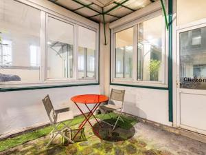 a red table and two chairs in a room with windows at Joli - Lovely studio Paris in Paris